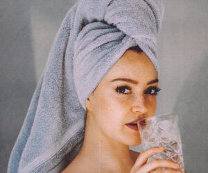 a woman drinks water in a towel